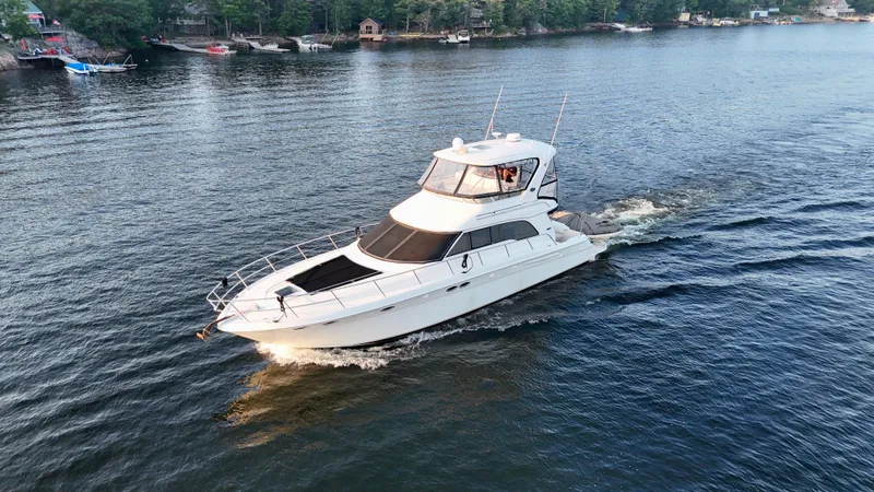 My Satin Doll Yacht Photos Pics 2001 Sea Ray 480 Sedan Bridge yacht cruising on a serene lake.
