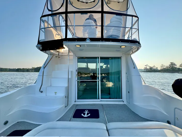 My Satin Doll Yacht Photos Pics 2001 Sea Ray 480 Sedan Bridge yacht, rear view, on calm water at sunset.