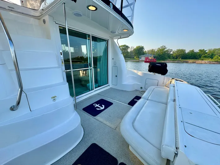 My Satin Doll Yacht Photos Pics 2001 Sea Ray 480 Sedan Bridge yacht deck with seating, overlooking calm waters and shoreline.