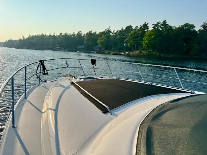 My Satin Doll Yacht Photos Pics 2001 Sea Ray 480 Sedan Bridge yacht cruising on a serene lake with forested shoreline.