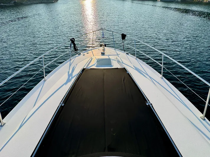 My Satin Doll Yacht Photos Pics Bow view of 2001 Sea Ray 480 Sedan Bridge yacht on calm water at sunset.