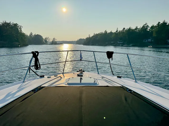 My Satin Doll Yacht Photos Pics 2001 Sea Ray 480 Sedan Bridge cruising at sunset on a serene lake.