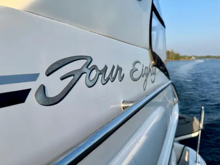 My Satin Doll Yacht Photos Pics Close-up of 2001 Sea Ray 480 Sedan Bridge boat nameplate, "Four Eighty," on water.