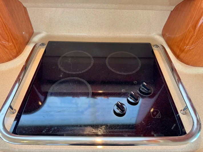 My Satin Doll Yacht Photos Pics Stovetop on 2001 Sea Ray 480 Sedan Bridge yacht, featuring sleek black design and control knobs.