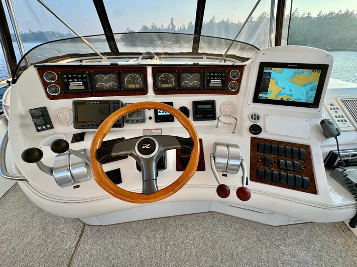 My Satin Doll Yacht Photos Pics 2001 Sea Ray 480 Sedan Bridge helm with navigation controls and wooden steering wheel.