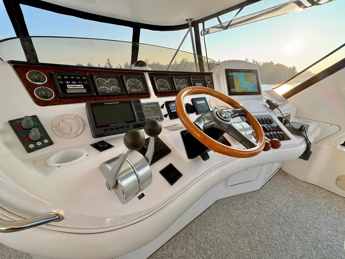 My Satin Doll Yacht Photos Pics Helm of 2001 Sea Ray 480 Sedan Bridge with navigation controls and wooden steering wheel.