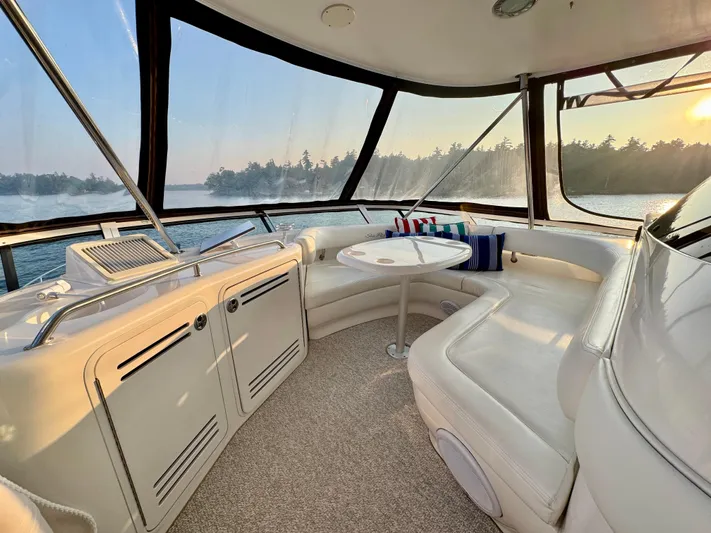 My Satin Doll Yacht Photos Pics Luxurious interior of 2001 Sea Ray 480 Sedan Bridge yacht with panoramic windows and plush seating.