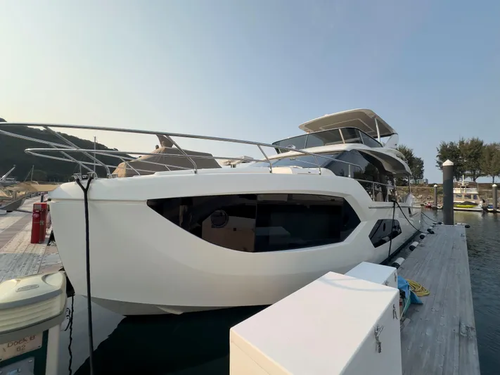  Yacht Photos Pics 2022 Absolute 60 Fly yacht docked at marina, side view.