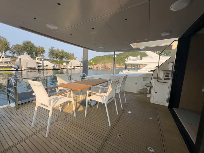  Yacht Photos Pics Luxury yacht Absolute 60 Fly 2022, featuring elegant outdoor dining area with scenic marina view.