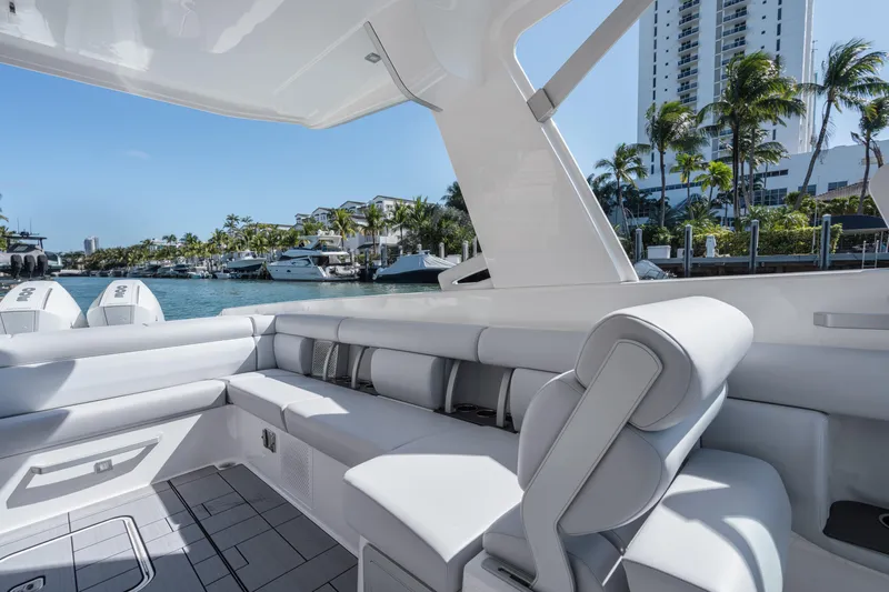 Pellicano Yacht Photos Pics 2023 Aviara AV36 OB luxury boat interior with sleek seating, docked near palm trees and buildings.