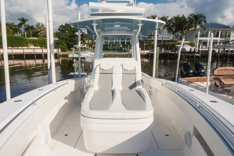  Yacht Photos Pics 2023 Invincible 36 Open Fisherman boat with luxurious seating, docked by waterfront homes.