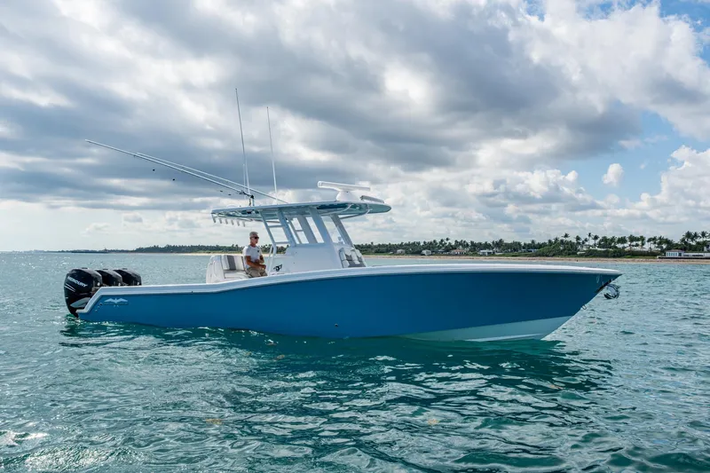  Yacht Photos Pics 2023 Invincible 36 Open Fisherman boat on calm ocean waters under cloudy sky.