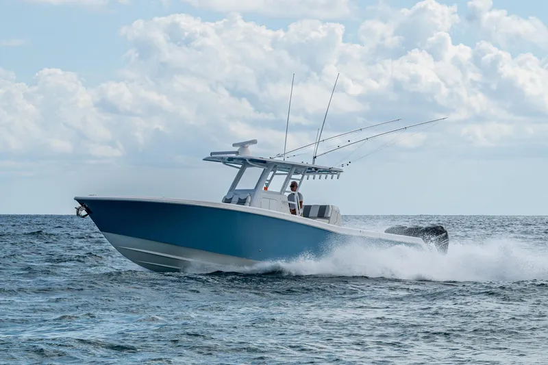  Yacht Photos Pics 2023 Invincible 36 Open Fisherman boat cruising on ocean waves under cloudy sky.