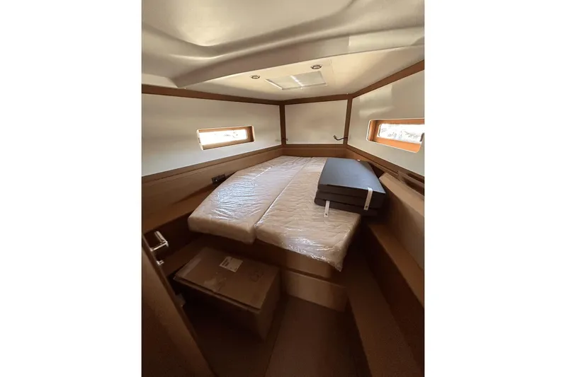  Yacht Photos Pics Cozy cabin interior of 2024 Beneteau First 44 yacht with bed and windows.