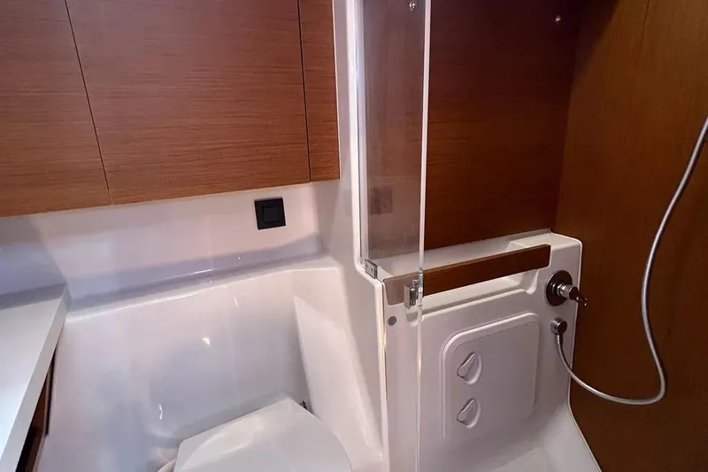  Yacht Photos Pics 2024 Beneteau First 44 yacht bathroom with modern fixtures and wooden cabinetry.