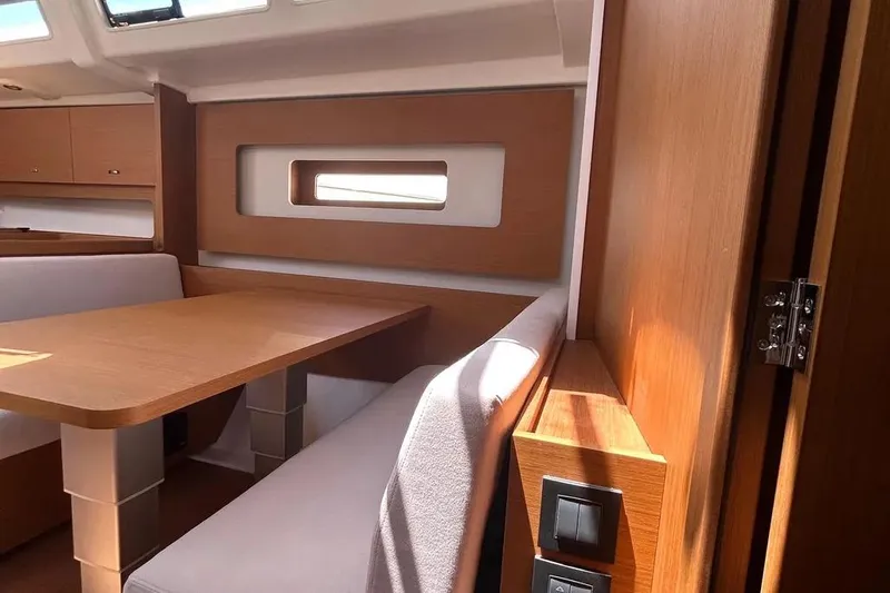  Yacht Photos Pics Interior of 2024 Beneteau First 44 yacht, featuring modern wood finish and seating area.