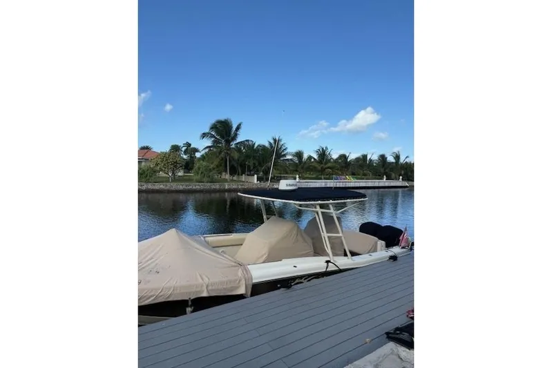  Yacht Photos Pics 2015 Chris-Craft Catalina 29 boat docked by a scenic waterfront with palm trees.