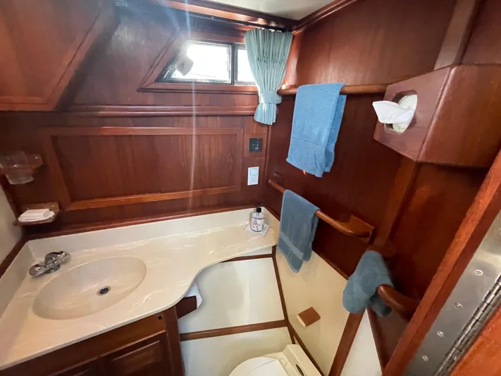 Safe N Sound Yacht Photos Pics 1988 Canoe Cove Tri Cabin bathroom with wood paneling, sink, and window.