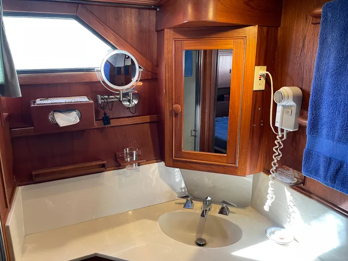 Safe N Sound Yacht Photos Pics 1988 Canoe Cove Tri Cabin bathroom with wooden cabinetry, sink, mirror, and towel.