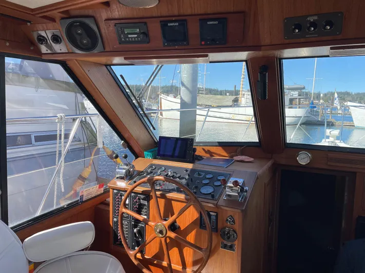 Safe N Sound Yacht Photos Pics 1988 Canoe Cove Tri Cabin helm with wooden steering wheel and navigation instruments.