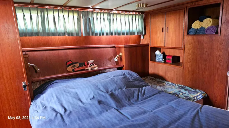 Safe N Sound Yacht Photos Pics Cozy bedroom in 1988 Canoe Cove Tri Cabin with wood paneling and blue bedding.