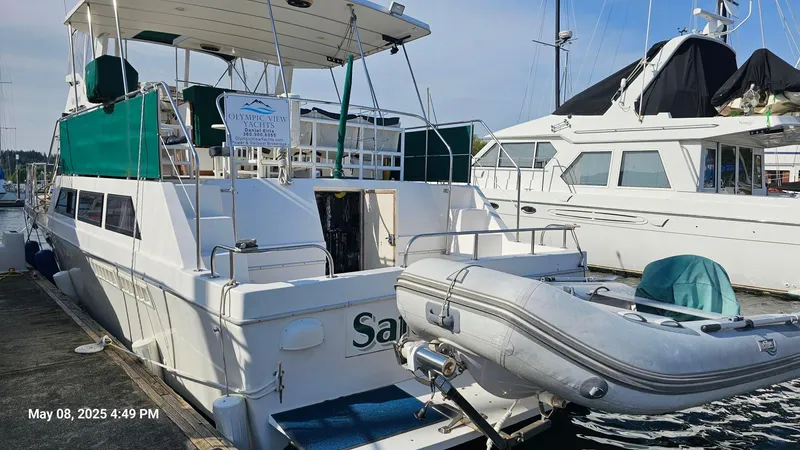 Safe N Sound Yacht Photos Pics 1988 Canoe Cove Tri Cabin yacht docked with inflatable boat attached, green canopy visible.