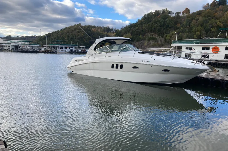  Yacht Photos Pics 2007 Sea Ray 38 Sundancer yacht docked on a calm lake with scenic background.