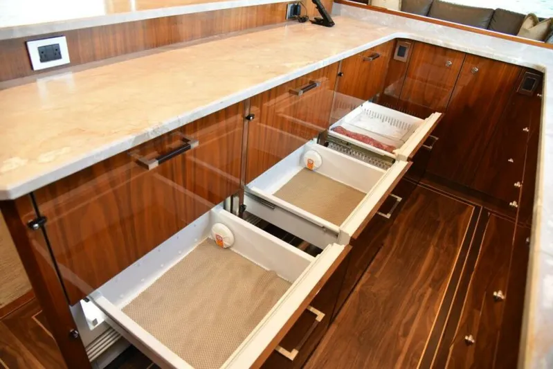 Another Day In Paradise Yacht Photos Pics Luxurious kitchen drawers in 2017 Viking 80 Sky Bridge yacht, featuring elegant wood finish.
