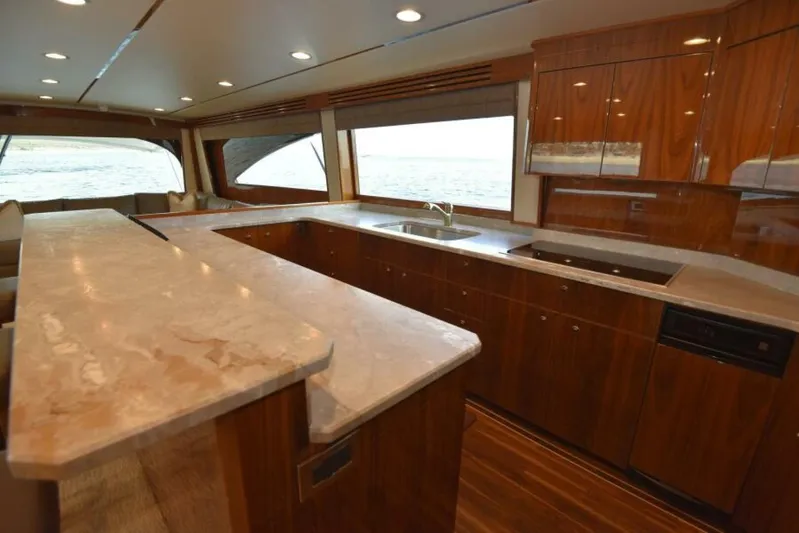 Another Day In Paradise Yacht Photos Pics Luxurious kitchen interior of 2017 Viking 80 Sky Bridge yacht with elegant wood cabinetry.