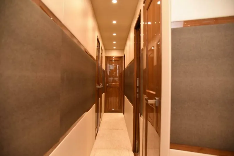 Another Day In Paradise Yacht Photos Pics Hallway interior of 2017 Viking 80 Sky Bridge yacht with wooden doors and soft lighting.