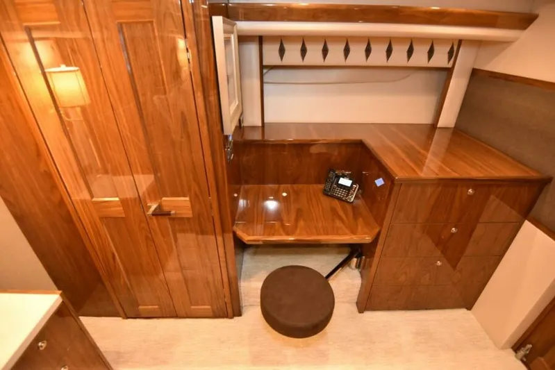 Another Day In Paradise Yacht Photos Pics Luxurious wooden interior of 2017 Viking 80 Sky Bridge yacht with desk and phone.