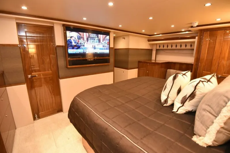 Another Day In Paradise Yacht Photos Pics Luxurious bedroom interior of 2017 Viking 80 Sky Bridge yacht with TV and elegant decor.