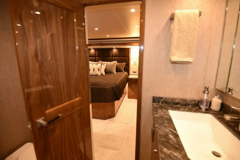 Another Day In Paradise Yacht Photos Pics Luxurious interior of 2017 Viking 80 Sky Bridge yacht, featuring elegant bedroom and bathroom.