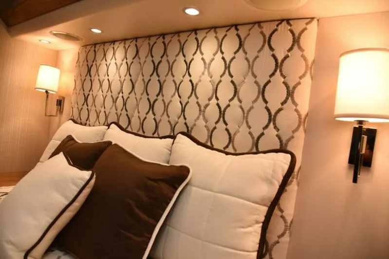 Another Day In Paradise Yacht Photos Pics Luxurious bedroom interior of 2017 Viking 80 Sky Bridge yacht with elegant lighting and cushions.