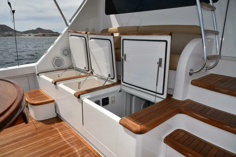 Another Day In Paradise Yacht Photos Pics 2017 Viking 80 Sky Bridge yacht deck with open storage compartments and wooden steps.