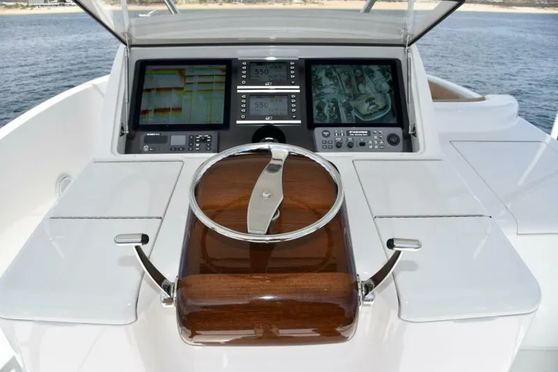 Another Day In Paradise Yacht Photos Pics Steering console of 2017 Viking 80 Sky Bridge yacht with navigation screens.