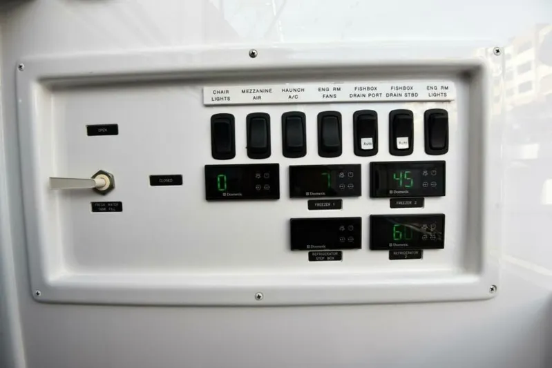Another Day In Paradise Yacht Photos Pics Control panel of a 2017 Viking 80 Sky Bridge yacht with switches and digital displays.