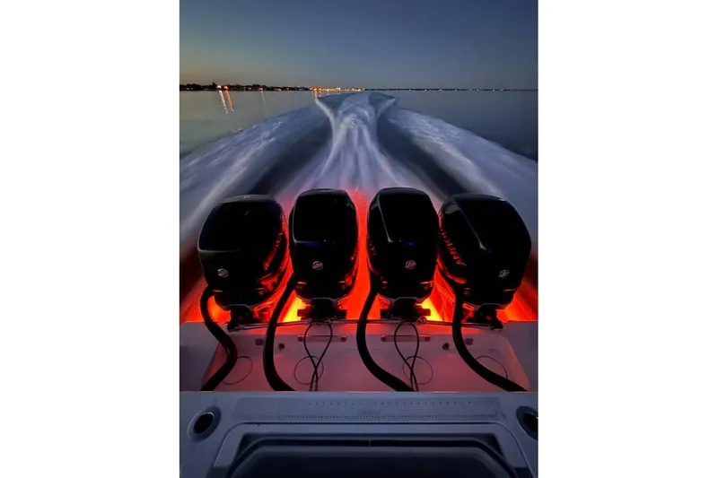  Yacht Photos Pics 2018 Invincible 42 Open Fisherman with four illuminated outboard engines at dusk.