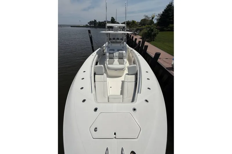  Yacht Photos Pics 2018 Invincible 42 Open Fisherman boat docked by a serene waterfront.