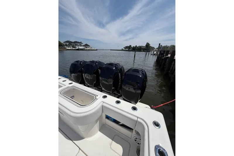  Yacht Photos Pics 2018 Invincible 42 Open Fisherman boat with multiple outboard engines docked by the water.