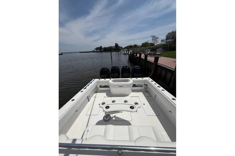  Yacht Photos Pics 2018 Invincible 42 Open Fisherman boat docked by a serene waterfront.