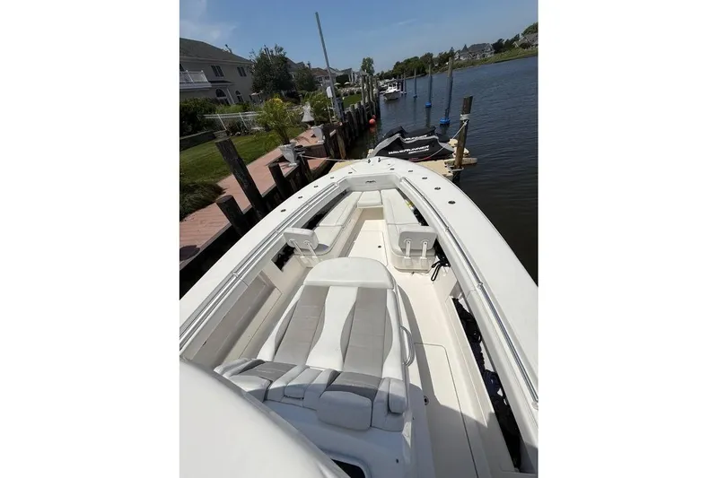  Yacht Photos Pics 2018 Invincible 42 Open Fisherman boat docked by waterfront homes.