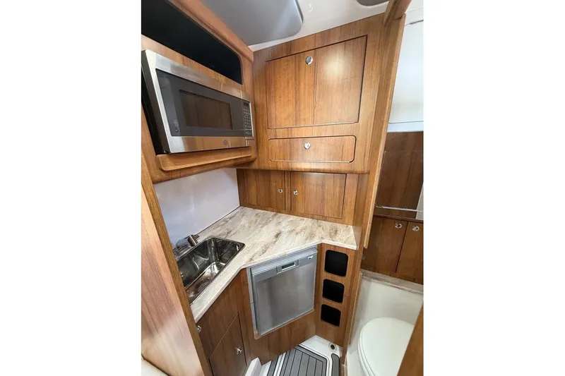  Yacht Photos Pics Compact kitchen area in 2018 Invincible 42 Open Fisherman boat with wood cabinetry.