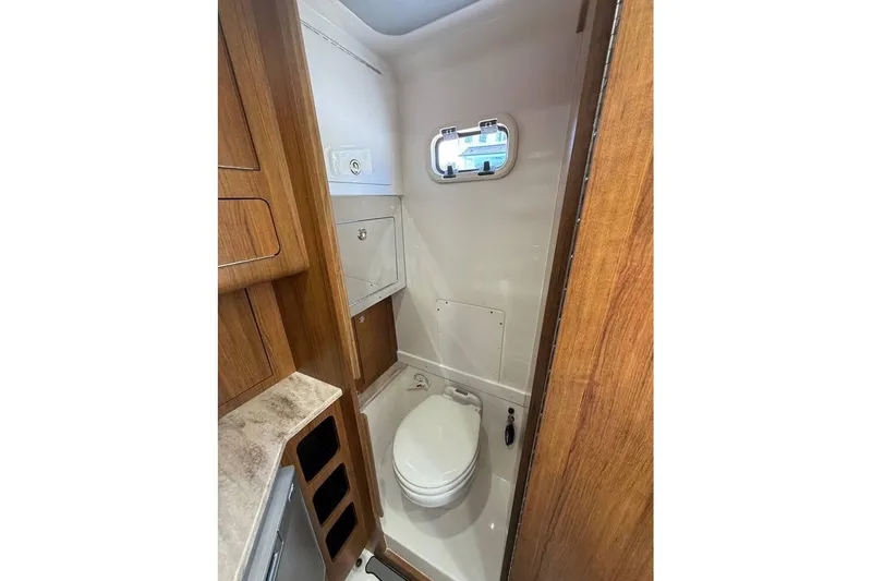  Yacht Photos Pics 2018 Invincible 42 Open Fisherman boat bathroom with wooden cabinetry and compact design.