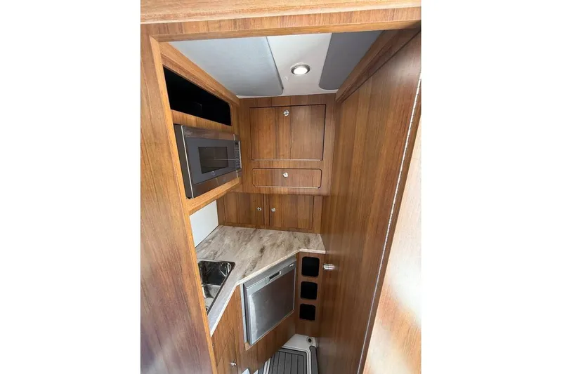  Yacht Photos Pics 2018 Invincible 42 Open Fisherman cabin interior with wood finish and modern appliances.
