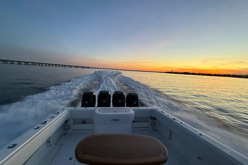  Yacht Photos Pics 2018 Invincible 42 Open Fisherman cruising at sunset, leaving a wake behind.