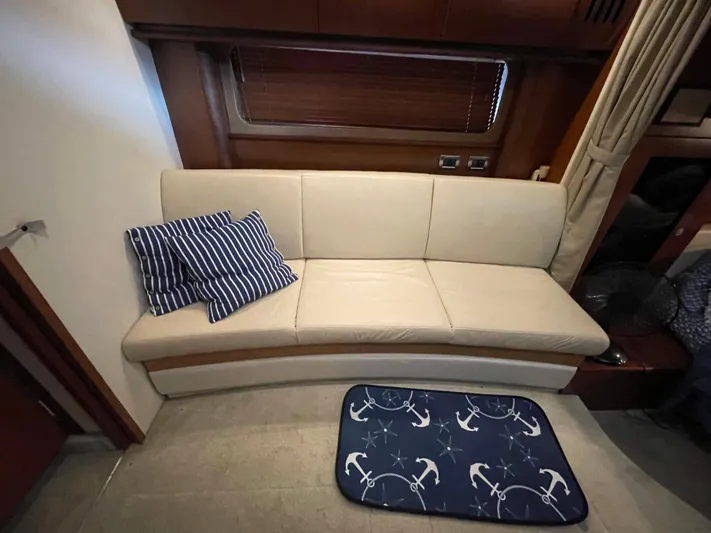  Yacht Photos Pics Interior of 2007 Sea Ray 38 Sundancer with beige sofa and nautical-themed mat.