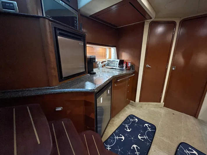  Yacht Photos Pics 2007 Sea Ray 38 Sundancer galley with modern appliances and wooden cabinetry.