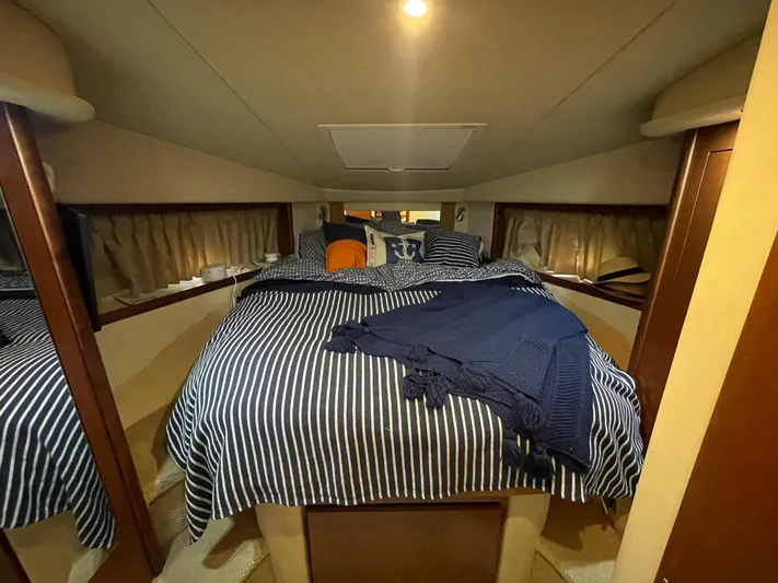  Yacht Photos Pics 2007 Sea Ray 38 Sundancer cabin with striped bedding and cozy lighting.