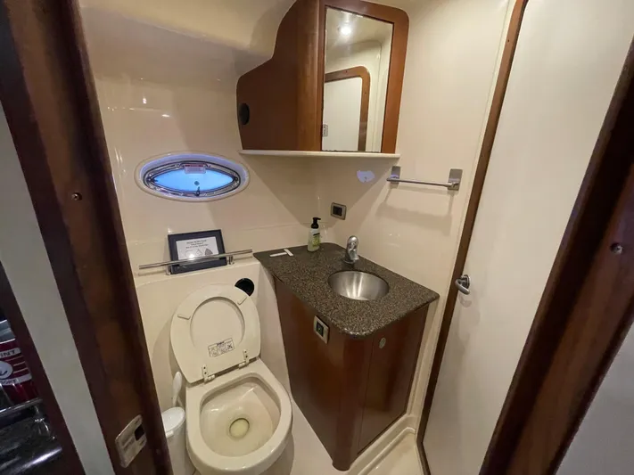  Yacht Photos Pics 2007 Sea Ray 38 Sundancer bathroom with toilet, sink, mirror, and porthole window.